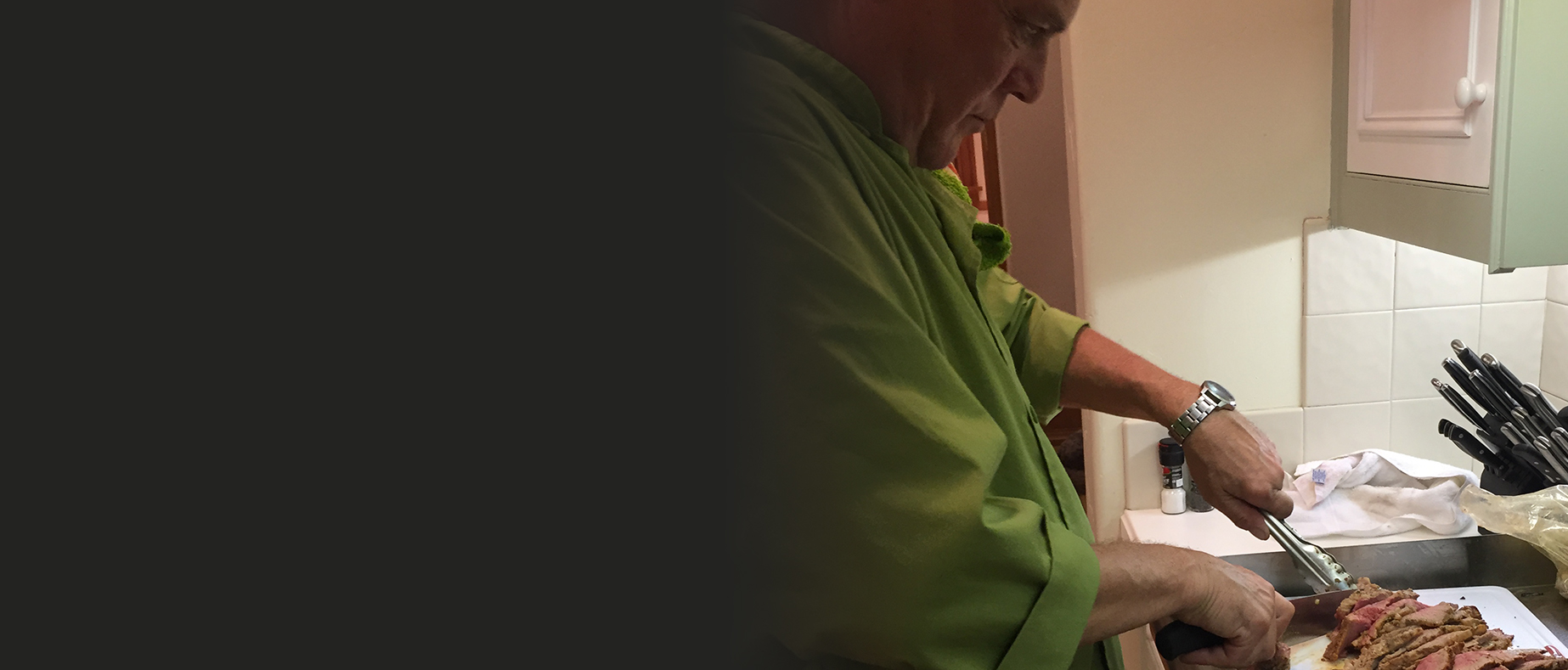 A man in green shirt looking at his phone.